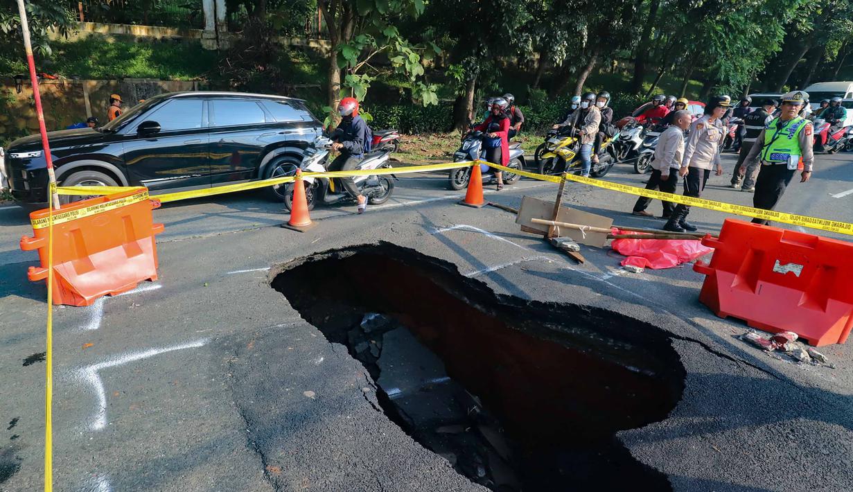 Pengendara melintas di sisi ruas jalan yang ditutup sebagian akibat amblas di Jalan Raya Lenteng Agung, Jakarta Selatan, Jumat (29/5/2026). (merdeka.com/Arie Basuki)