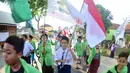 Sejumlah santri dari Pondok Pesantren Ashabul Kahfi membawa bendera Merah Putih saat mengikuti pawai Hari Santri Nasional 2017 di Gunungpati, Semarang (22/10). (Liputan6.com/Gholib)