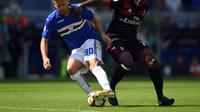 Gelandang Sampdoria, Gaston Ramirez (kiri) berebut bola dengan pemain AC Milan, Franck Kessie, pada laga lanjutan Serie A, di Stadion Luigi Ferraris, Minggu (24/9/2017). (AFP/Filippo Monteforte). 