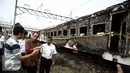 Menhub Budi Karya menyimak keterangan warga saat meninjau lokasi terbakarnya dua gerbong kereta Kerta Jaya kelas Ekonomi di dekat Stasiun Tanjung Priok, Jakarta, Kamis (25/8). (Liputan6.com/Faizal Fanani)