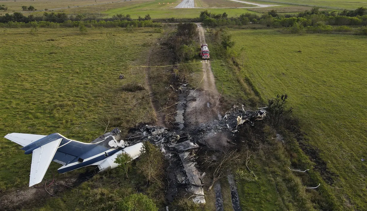 Sisa-sisa pesawat yang terbakar setelah gagal lepas landas dari Bandara Eksekutif Houston terlihat di Brookshire, Texas, Amerika Serikat, Selasa (19/10/2021). Pesawat gagal lepas landas lalu terjatuh dan terbakar. (Godofredo A. Vásquez/Houston Chronicle via AP)