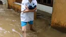 Seorang siswi melintasi banjir yang melanda Kampung Melayu, Jakarta Timur, Senin (25/6). (Liputan6.com/Arya Manggala)
