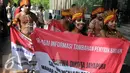Sejumlah pemuda Papua mengenakan pakaian adat membawa spanduk berunjuk rasa di depan Gedung KPK, Jakarta, Senin (19/12). Mereka meminta KPK mengusut kasus korupsi pejabat yang mencalonkan diri pada Pilkada Jayapura 2017. (Liputan6.com/Helmi Affandi)