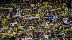 Para suporter saat mendukung tim kesayangannya bertanding pada putaran ketiga kualifikasi UEFA Europa League antara Fenerbahce dan Sturm Graz di Stadion Ulker Fenerbahce di Istanbul (3/8). Fenerbahce bermain imbang 1-1. (AFP Photo/Ozan Kose)