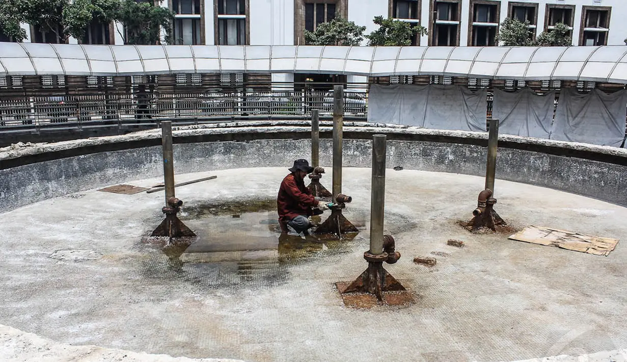 Pekerja menyelesaikan proyek rehabilitasi air mancur di kawasan Kota Tua, Jakarta, Rabu (5/11/2014). (Liputan6.com/Faizal Fanani)  