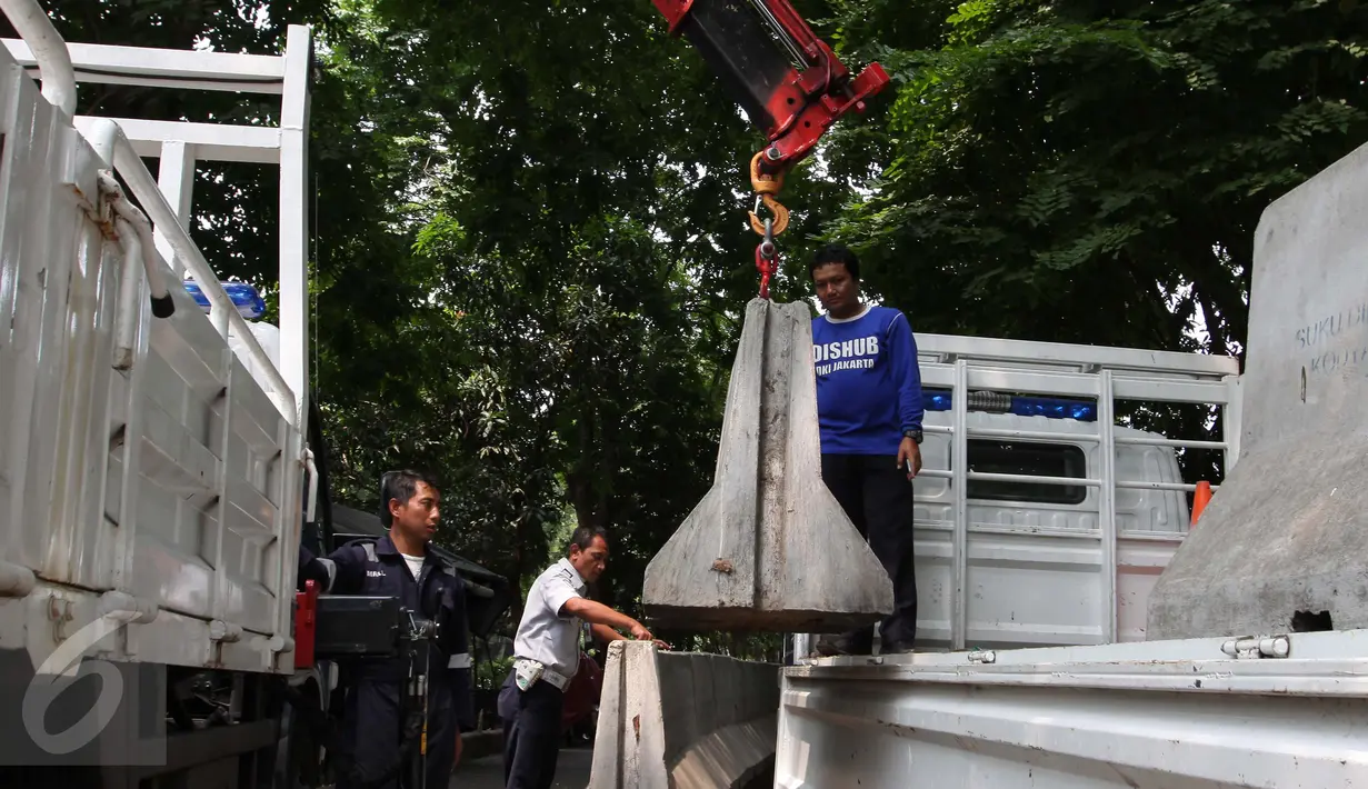 Petugas Dishub membongkar beton pembatas Jalan M. Yamin di depan bekas gedung Kedubes Inggris, Jakarta, Kamis (17/9/2015). Pembongkaran dilakukan karena beton tersebut akan dipergunakan di tempat lain. (Liputan6.com/Angga Yuniar)