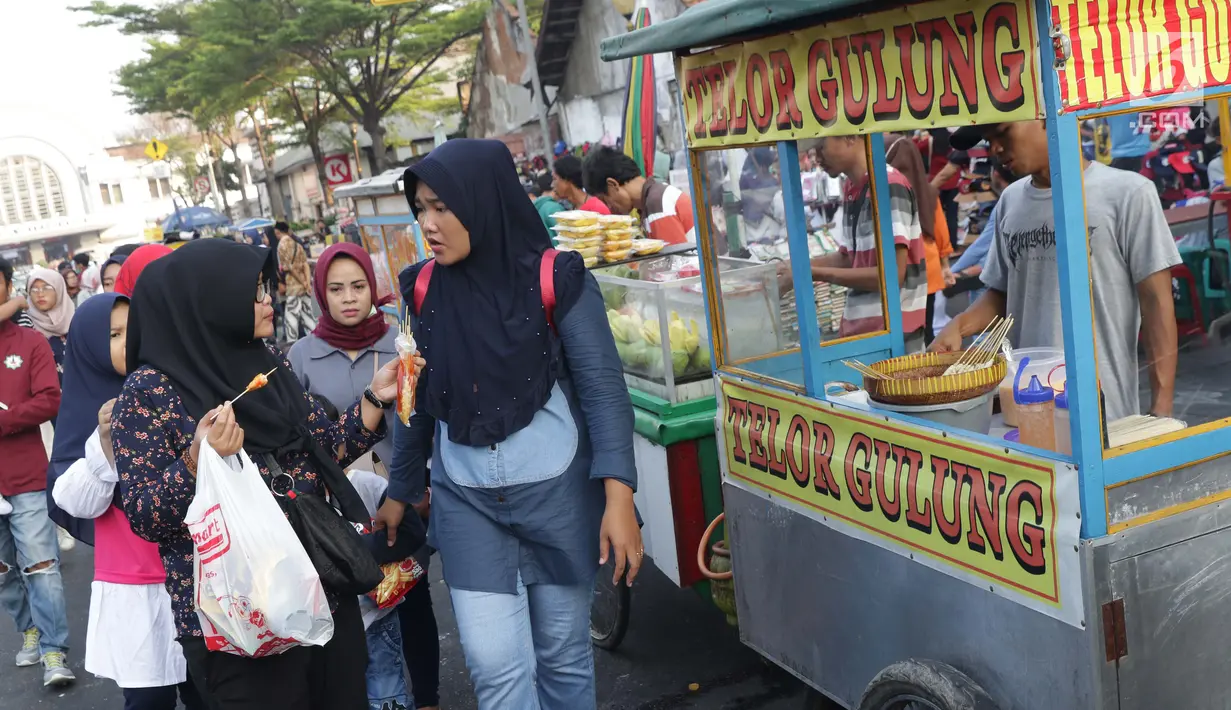 Warga berjalan di depan pedagang kaki lima yang berdagang di sebagian ruas Jalan Lada samping Kawasan Wisata Museum Fatahillah, Jakarta, Selasa (11/6/2019). Kondisi ini menyulitkan wisatawan pejalan kaki dan membuat arus lalu lintas di Jalan Lada menjadi semrawut. (Liputan6.com/Helmi Fithriansyah)