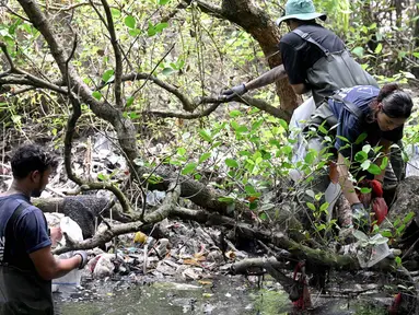 Warga membersihkan sampah plastik di area hutan bakau sebagai bagian dari kampanye kebersihan di Desa Serangan, Denpasar, Bali, pada Rabu 15 April 2026. Sampah plastik yang menumpuk di hutan bakau Desa Serangan, Denpasar, Bali, menjadi ancaman serius bagi ekosistem mangrove. (SONNY TUMBELAKA/AFP)