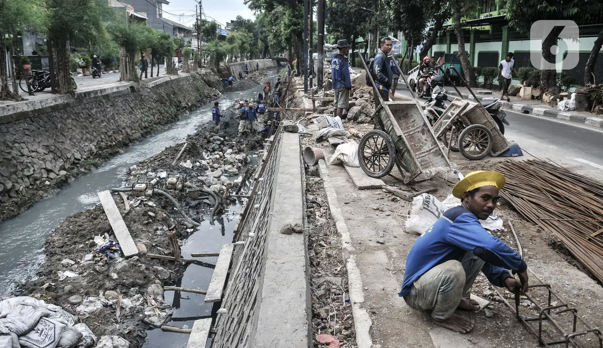 Pekerja Suku Dinas Sumber Daya Air Jakarta Timur menyelesaikan perbaikan turap di Kali Utan Kayu, Jakarta, Rabu (15/7/2020). Perbaikan turap yang ditargetkan rampung pada akhir Agustus 2020 tersebut bertujuan memperlancar aliran kali dan mencegah terjadinya banjir. (merdeka.com/Iqbal S. Nugroho)