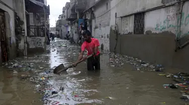 Seorang pria membersihkan jalan yang banjir setelah hujan deras, di Karachi, Pakistan, Selasa (30/7/2019). Departemen Meteorologi Pakistan mengatakan bahwa hujan memasuki provinsi Sindh dari Rajasthan India dan memperkirakan hujan akan turun tiga hari lagi. (AP Photo/Fareed Khan)