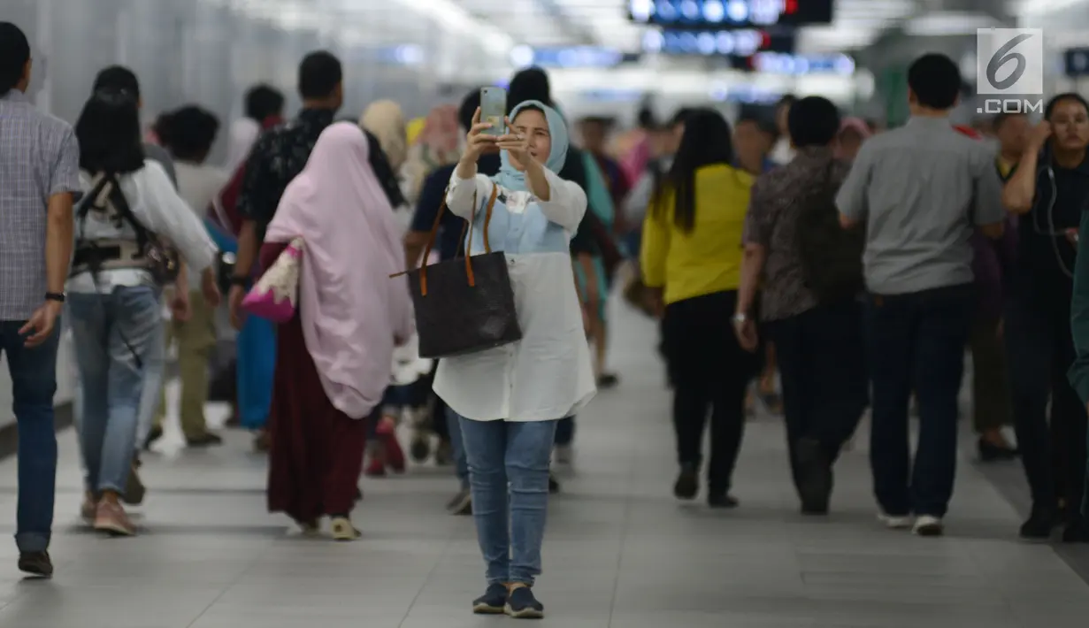 Seorang warga berselfie sebelum mencoba menaiki moda raya Terpadu  Mass Rapid Transit  MRT di Stasiun MRT Bundaran HI, Jakarta, Jumat (29/3). Terkait tarif kereta MRT minimum yag telah disepakati adalah Rp.3000 sampai maksimum Rp.14.000 dari Lebak Bulus- Bundaran HI. (merdeka.com/Imam Buhori)