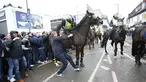  Petugas kepolisian berusaha membubarkan seorang suporter saat terlibat bentrok sebelum pertandingan perempat final Piala FA antara Tottenham Hotspur melawan Millwall di White Hart Lane, London, (12/3). (Yui Mok//PA via AP)