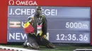 Pelari Uganda Joshua Cheptegei berpose dekat depan papan waktu usai memenangkan 5.000 meter putra pada final kejuaraan Monaco Diamond League 2020 di Stadion Louis II, Monako, Jumat (14/8/2020). Joshua memecahkan rekor dunia lari 5.000 meter dengan catatan waktu 12:35,36. (Eric Gaillard/Pool Via AP)