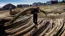 Seorang pekerja membawa rotan untuk dikeringkan untuk diekspor di sebuah bengkel di Banda Aceh (7/1/2020). Aceh merupakan salah satu sentra produksi rotan terbesar di Sumatera.  (AFP Photo/Chaideer Mahyuddin)