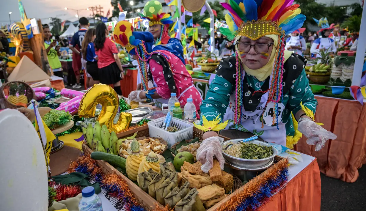 Berbagai peserta tampil kreatif dengan memadukan unsur olahraga sepak bola internasional bersama kekayaan kuliner khas Surabaya. Tampak dalam foto, para peserta yang mengenakan seragam tim sepak bola menyiapkan rujak uleg, salad gurih tradisional Indonesia yang berisi moncong sapi dan sayuran, dalam Festival Rujak Uleg 2026 di Surabaya, Jawa Timur, Sabtu 9 Mei 2026. (JUNI KRISWANTO/AFP)