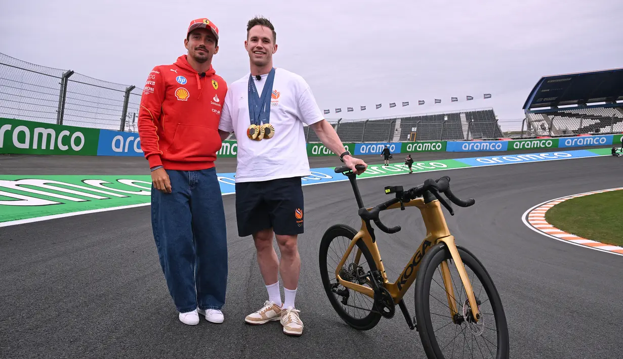 Pembalap Ferrari, Charles Leclerc (kiri) berfoto bersama dengan atlet balap sepeda track Belanda, Harrie Lavreysen menjelang Formula 1 GP Belanda di Sirkuit Zandvoort, Kamis (22/08/2024) waktu setempat. (AFP/John Thys)