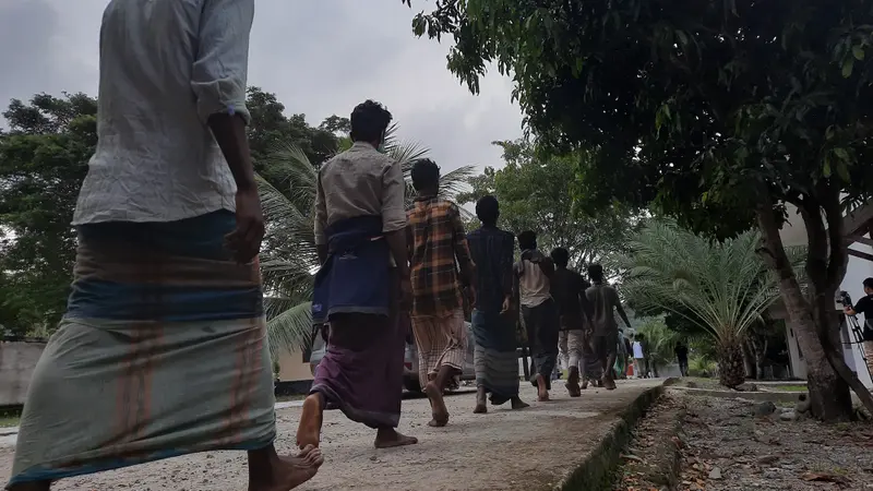 Pengungsi Rohingya yang terdampar di Desa Ladong, Kecamatan Masjid Raya Aceh Besar, Minggu pagi (25/12/2022) sedang berbaris menuju ke menasah di pekarangan sebuah kantor milik pemerintah (Liputan6.com/Rino Abonita)