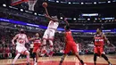 Pemain Chicago Bulls, Jimmy Butler  melakukan layup melewati hadangan para pemain Washington Wizards  pada laga NBA basketball game di United Center, Chicago, (21/12/2016).  Wizards menang 107-97. (Reuters/Mike DiNovo-USA TODAY Sports)