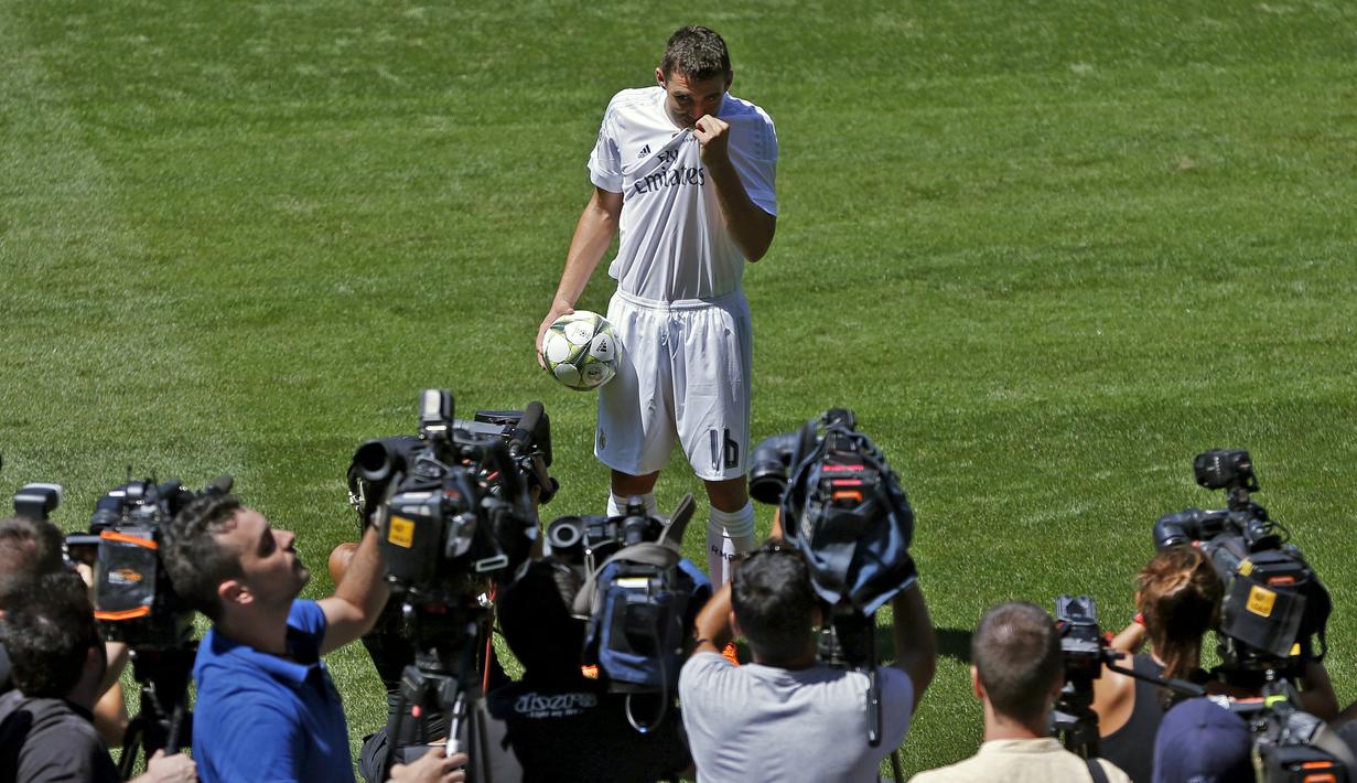 Mateo Kovacic mencium lambang klub saat diperkenalkan sebagai pemain baru Real Madrid di Stadion Santiago Bernabeu. (19/8/2015). (Reuters/Juan Medina)