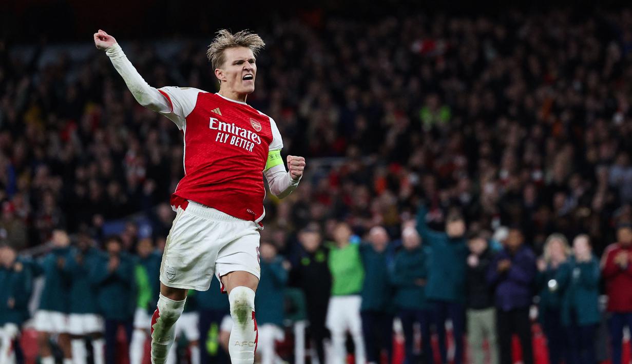Pemain Arsenal, Martin Odegaard melakukan selebrasi setelah berhasil mengeksekusi tendangan penalti ke gawang Porto pada laga leg kedua 16 besar Liga Champions 2023/2024 di Emirates Stadium, London, Inggris, Rabu (13/03/2024). (AFP/Adrian Dennis)