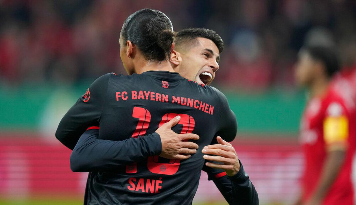 Cancelo pun tak dapat menutupi kebahagiannya dan langsung berpelukan Leroy Sane. (AP Photo/Michael Probst)