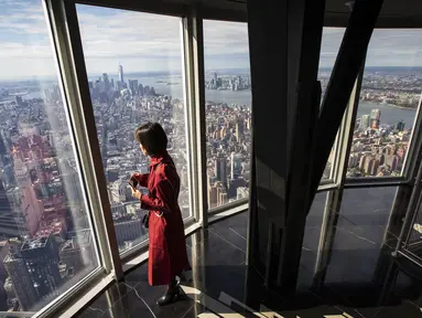 Seorang wanita menikmati pemandangan Kota Manhattan dari ruangan observatorium di lantai 102 Gedung Empire State yang baru direnovasi di New York (10/10/2019). Dibuka untuk umum pada 12 Oktober, ruang observatorium ini berjarak 1.250 kaki di atas permukaan jalan. (AFP Photo/Drew Angerer)