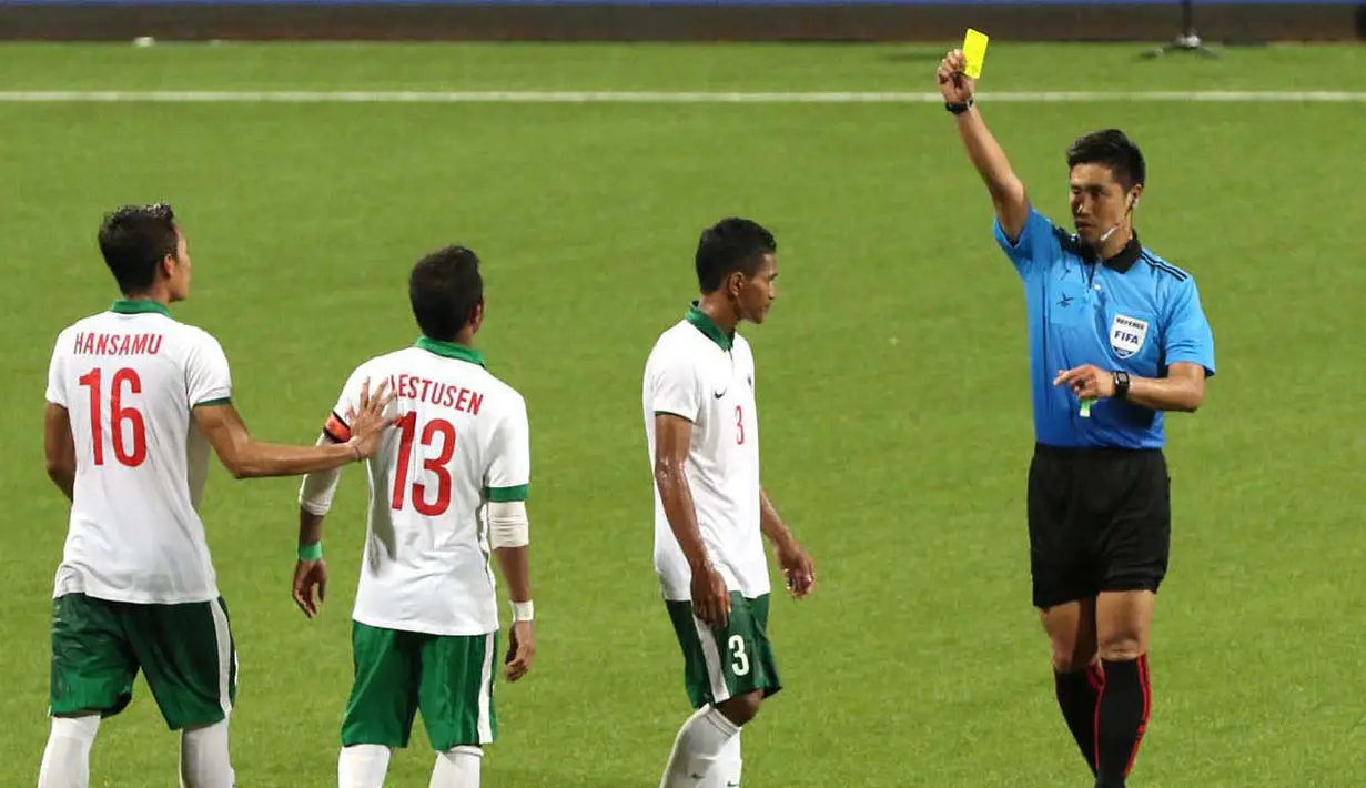 Wasit Kim Heegon dari Korea memberikan kartu kuning kepada pemain Indonesia U-23, M. Abduh Lestaluhu (3) setelah melakukan pelanggaran terhadap pemain Myanmar U-23. (Bola.com/Arief Bagus)