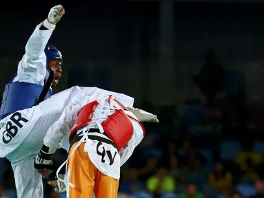  Helm taekwondoin Pantai Gading, Cheikh Sallah Cisse, terlepas setelah terkena tendangan atlet Inggris Raya, Lutalo Muhammad (kiri), dalam final kelas -80kg Olimpiade Rio 2016 di Rio de Janeiro, Brasil, (19/8/2016). (Reuters/Peter Cziborra)