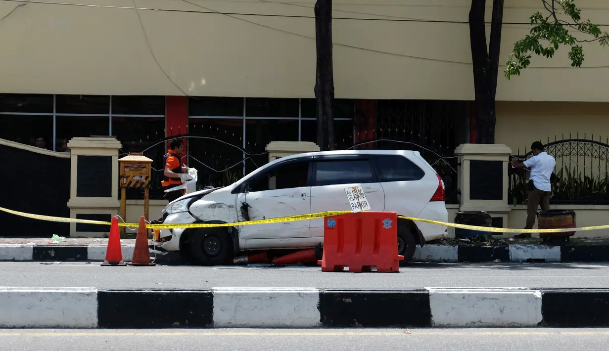 Petugas kepolisian memeriksa mobil yang digunakan terduga teroris setelah serangan di luar markas polisi di Pekanbaru, Riau (16/5). Empat pelaku penyerangan ditembak dan tewas ketika mereka melakukan serangan.  (AFP Photo/Dedy Sutisna)