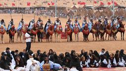 Penunggang kuda dan para wanita berkumpul dalam Festival Tan-Tan Moussem Berber ke-14 di Kota Tan-Tan, Maroko, Minggu (8/7). Festival ini untuk mempromosikan tradisi lokal dan menyatukan suku nomaden dari Afrika Utara. (KARIM SAHIB/AFP)