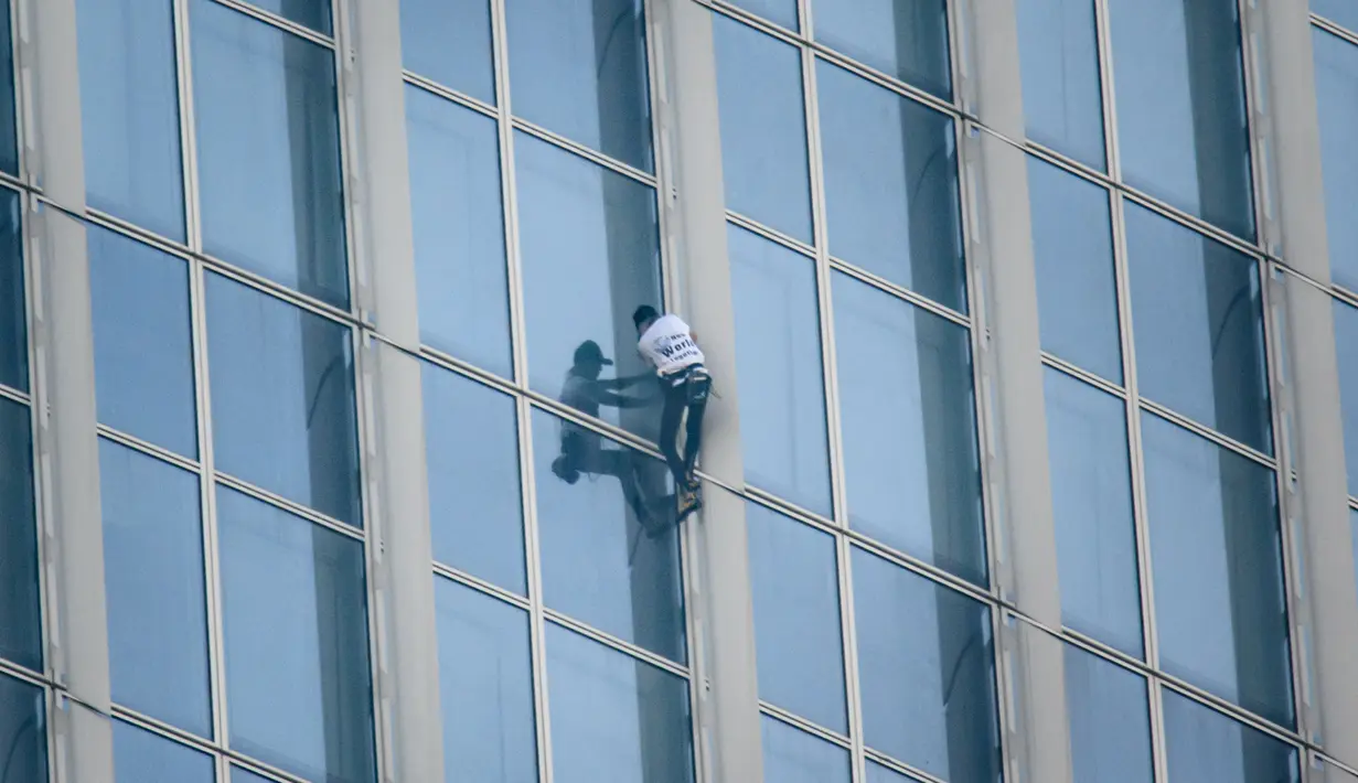 Urban climber Alain Robert beraksi memanjat Menara Lotte World di Seoul, Korea Selatan (6/6). Alain Robert memang terkenal karena hobinya memanjat bangunan tinggi, ia juga diberi gelar "French Spiderman". (AFP/Ed Jones)