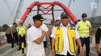 Menteri PUPR Basuki Hadimuljono (kanan) mendengarkan Bupati Batang Wihaji berbicara usai uji coba Jembatan Kali Kuto di Batang, Jateng, Rabu (13/6). Hadi mengatakan Jembatan Kali Kuto akan dioperasikan selama 24 jam. (Liputan6.com/Arya Manggala)