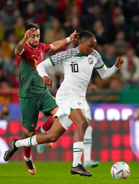 Pemain Nigeria Joseph Ayodele-Aribo (kanan) berebut bola dengan pemain Portugal Bruno Fernandes pada pertandingan persahabatan di Stadion Jose Alvalade, Lisbon, Portugal, 17 November 2022. Portugal menghajar Nigeria dengan skor telak 4-0, mereka akan berangkat ke Qatar pada 18 November untuk Piala Dunia 2022. (AP Photo/Armando Franca)