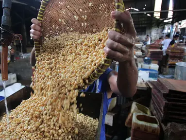 Pekerja tengah mengangkat kacang kedelai untuk dijadikan bahan dasar pembuatan tahu di Jakarta, Rabu (6/1/). Indonesia masih bergantung pada kedelai impor karena minimnya produksi kedelai di dalam negeri. (Liputan6.com/Angga Yuniar)