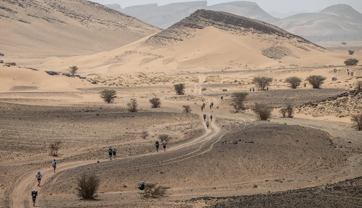 Sejumlah pelari berkompetisi pada stage pertama Marathon des Sables 2023 yang menempuh antara Jebel Irhs hingga Oued Tijekht di Gurun Sahara, Maroko, 24 April 2023. Ajang yang berlangsung dari 21 April hingga 1 Mei 2023 tersebut diikuti oleh 1200 pelari dan akan menempuh 250 km. (AFP/Jean-Philippe Ksiazek)