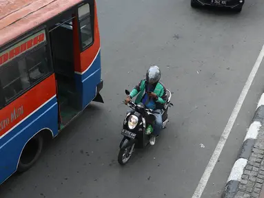 Pengendara sepeda motor mengoperasikan gawainya saat berkendara di Jakarta, Jumat (8/2). Polisi akan melakukan tindakan hukum berupa tilang kepada pengendara yang menggunakan GPS saat berkendara. (Liputan6.com/Immanuel Antonius)