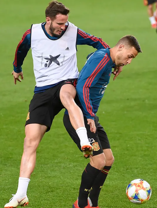 Gelandang Spanyol, Saul Niguez (kiri) berebut bola dengan dengan gelandang Sergio Canales selama sesi latihan di stadion Mestalla di Valencia (22/3). Spanyol akan bertanding melawan Norwegia pada grup F kualifikasi Euro 2020. (AFP Photo/Jose Jordan)