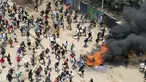 Para pengunjuk rasa berlari ke arah petugas polisi anti huru hara saat unjuk rasa massal di Kibera Slums, Nairobi, Senin, 27 Maret 2023. (AP Photo/Brian Inganga)