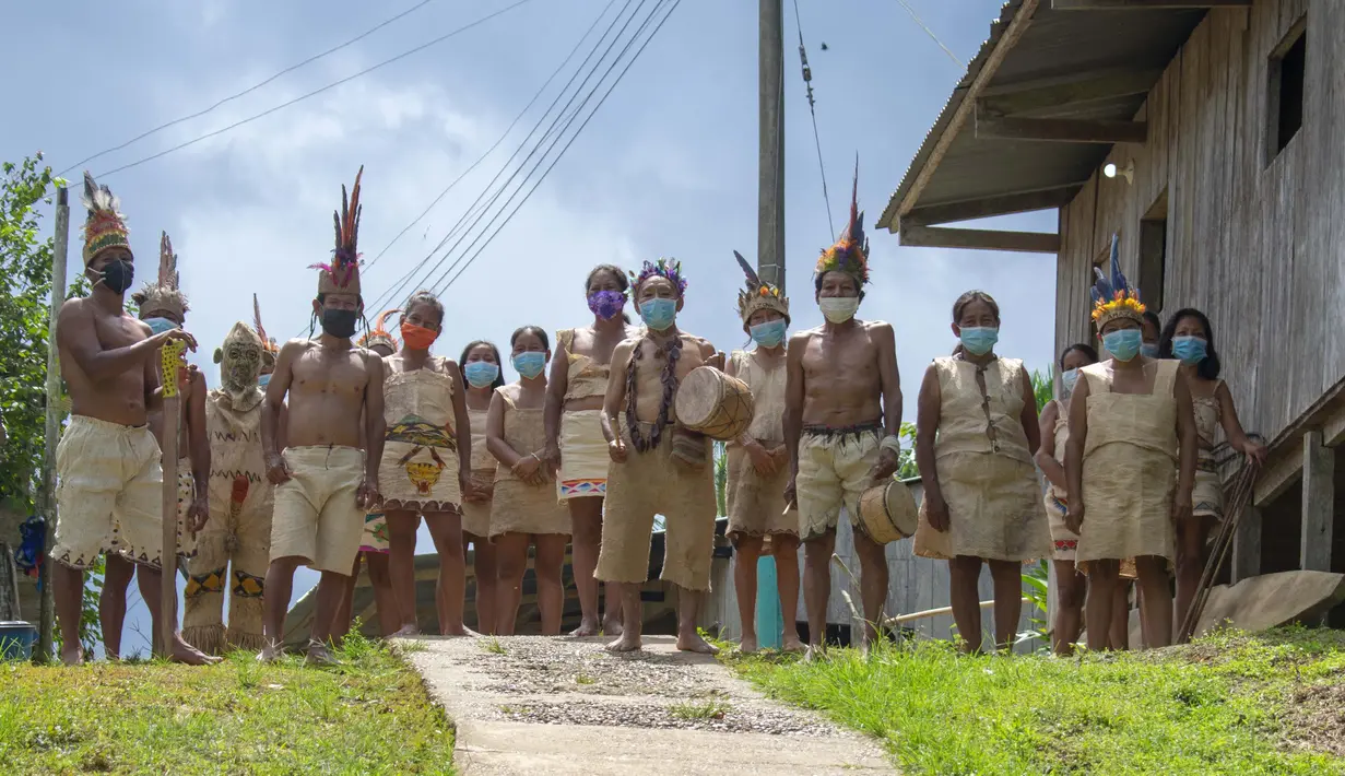 Suku Tikuna berpose mengenakan masker di tengah kekhawatiran virus corona Covid-19 di Leticia, Departemen Amazonas, Kolombia pada 8 Juni 2020. Kasus virus corona ini meningkatkan kekhawatiran akan resiko penyebaran ke masyarakat adat yang rentan dan berada di pedalaman. (Tatiana de NEVO/AFP)