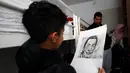 Farhad Nouri berfoto dengan gambar pelukis surealis Salvador Dali yang dibuatnya, di kamarnya di dekat Belgrade, Serbia, 13 Maret 2017. Bocah Afganistan berusia 10 tahun ini dikenal dengan julukan Little Picasso karena bakat seninya. (AP/Darko Vojinovic)