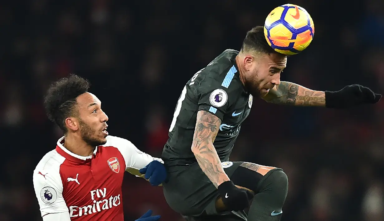 Bek Manchester City, Nicolas Otamendi, membuang bola dari striker Arsenal, Pierre-Emerick Aubameyang, pada laga Premier League di Stadion Emirates, London, Kamis (1/3/2018). Arsenal kalah 0-3 dari City. (AFP/Glyn Kirk)