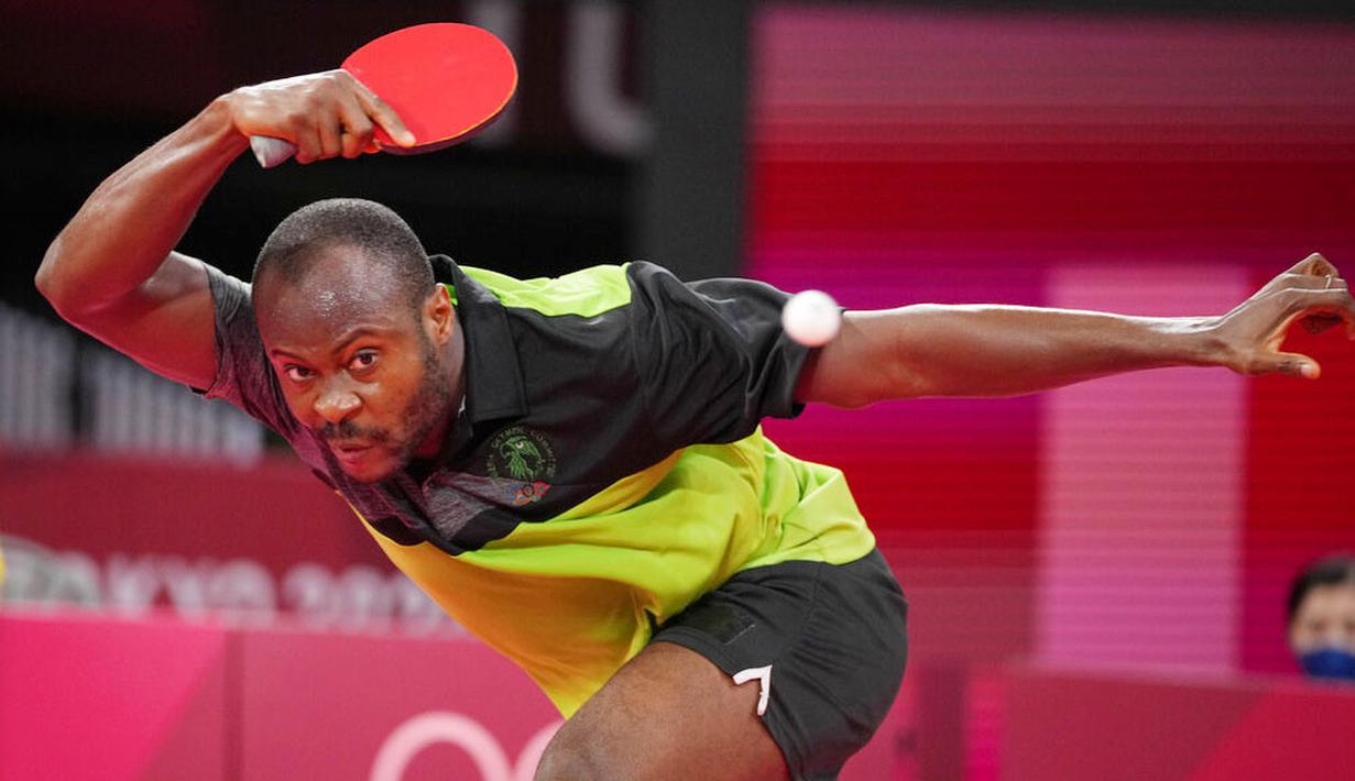 Petenis Nigeria, Quadri Aruna, berusaha mengembalikan bola saat bertanding melawan atlet tenis meja Brasil, Gustavo Tsuboi, pada pertandingan putaran ketiga di Olimpiade Tokyo 2020, Selasa, (27/7/2021). (Foto: AP/Kin Cheung)