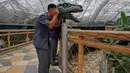 Seorang pria melihat melalui perangkat untuk mempelajari visi dinosaurus di Kebun Binatang di Pyongyang, Korea Utara (15/9). Kebun binatang nasional Korea Utara ini  terletak dekat Mt. Taesong di pusat kota Pyongyang. (AP Photo/Kin Cheung)