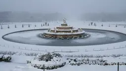 Kota Paris di Prancis berselimut salju tebal, menyusul penurunan suhu ekstrem hingga di bawah 0 derajat Celsius. Tampak dalam foto, salju menyelimuti Kolam Latona dan Parterre di taman Versailles, luar Kota Paris pada Selasa 6 Januari 2026. (GEOFFROY VAN DER HASSELT/AFP)