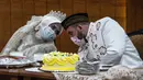 Pasangan pengantin Yavuz Ozdemir dan Irra Chorina Octora menganakan masker saat melangsungkan pernikahan di Surabaya, Jawa Timur, Indonesia, 25 Maret 2020. Organisasi Kesehatan Dunia (WHO) mengumumkan virus corona COVID-19 sebagai pandemi sejak 11 Maret 2020 lalu. (Juni Kriswanto/AFP)