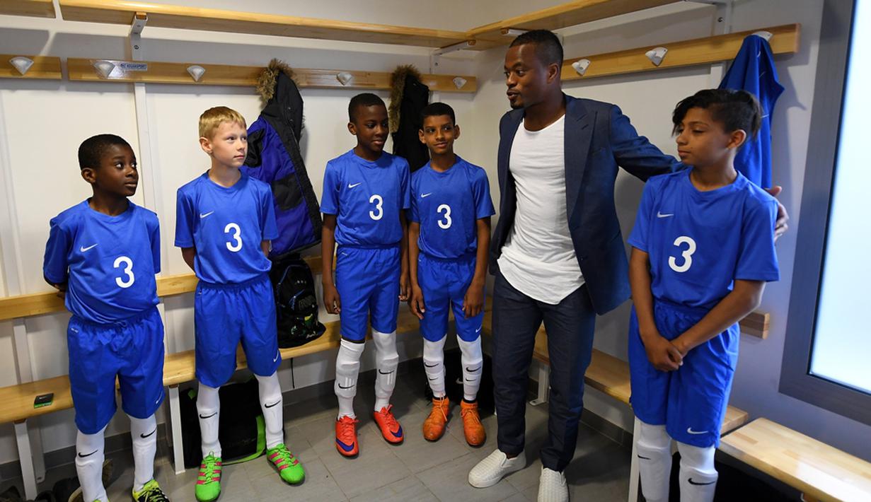 Pemain Timnas Prancis, Patrice Evra, memberi wejangan kepada para pemain muda Les Ulis di ruang ganti sebelum bertanding, (23/5/2016). (AFP/Franck Fife) 