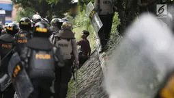 Polisi menginterogasi seorang pria saat tarjadi bentrok dengan massa di kawasan Petamburan, Jakarta Barat, Rabu (22/5/2019). Hingga pukul 11.30 WIB, situasi berangsur kondusif. (Liputan6.com/Faizal Fanani)