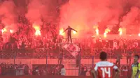Suporter Madura United, menyalakan flare memperingati ulang tahunnya membuat laga melawanRPersiba Balikpapan tertunda pada Torabika SC2016 di Stadion Gelora Bangkalan, Senin(13/6/2016).  (Bola.com/Nicklas Hanoatubun)