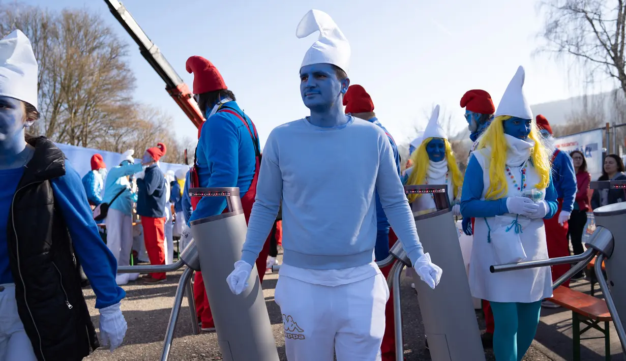 Orang-orang berpakaian dan berdandan serba biru seperti Smurf dalam upaya pemecahan rekor dunia di Lauchringen, Jerman, 16 Februari 2019. Pertemuan tersebut untuk memecahkan rekor orang dengan kostum Smurf terbanyak di dunia. (CONSTANT FORME-BECHERAT/AFP)