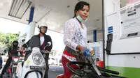 Petugas dengan pakaian adat mengisi bahan bakar minyak (BBM) untuk sepeda motor di SPBU, Bali, Rabu (10/10). Petugas SPBU mengenakan pakaian adat Bali untuk menyambut pertemuan tahunan IMF dan Bank Dunia. (Liputan6.com/Angga Yuniar)